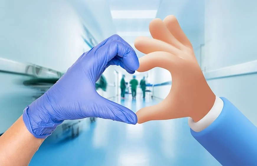 A gloved hand and a cartoon hand forming a heart in a hospital corridor